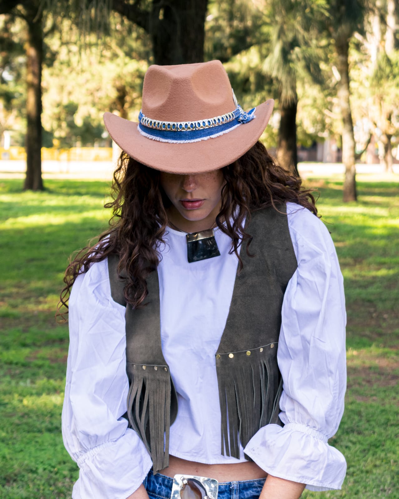 Modelo con sombrero de paño camel customizado con banda de jean y trenzado blanco